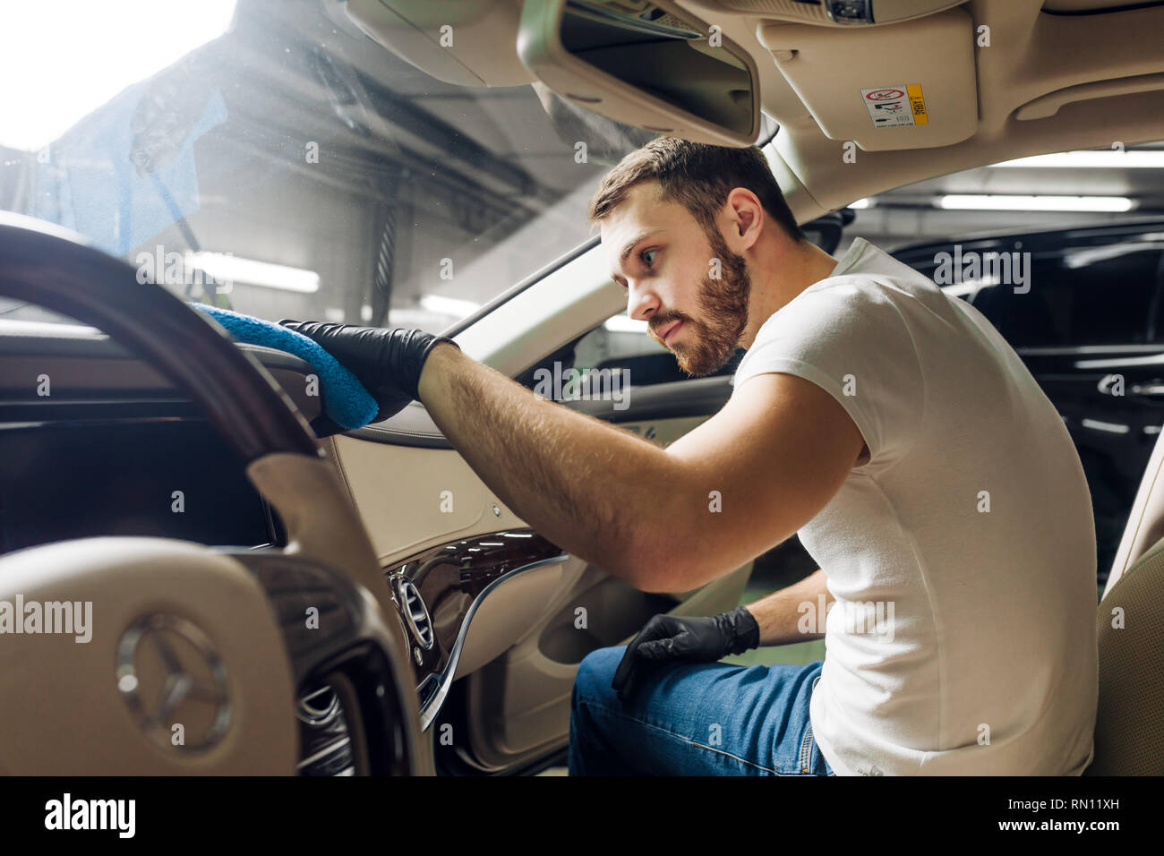 Hombre atractivo se concentra en la limpieza del coche, cerca de foto de  tiempo libre Fotografía de stock - Alamy