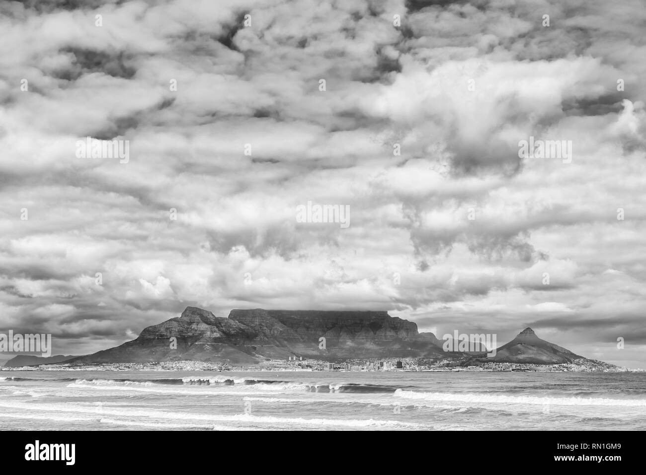 El distrito central de negocios de Ciudad del Cabo y Table Mountain como se ve a través de la Bahía de Table desde Bloubergstrand. Monocromo Foto de stock