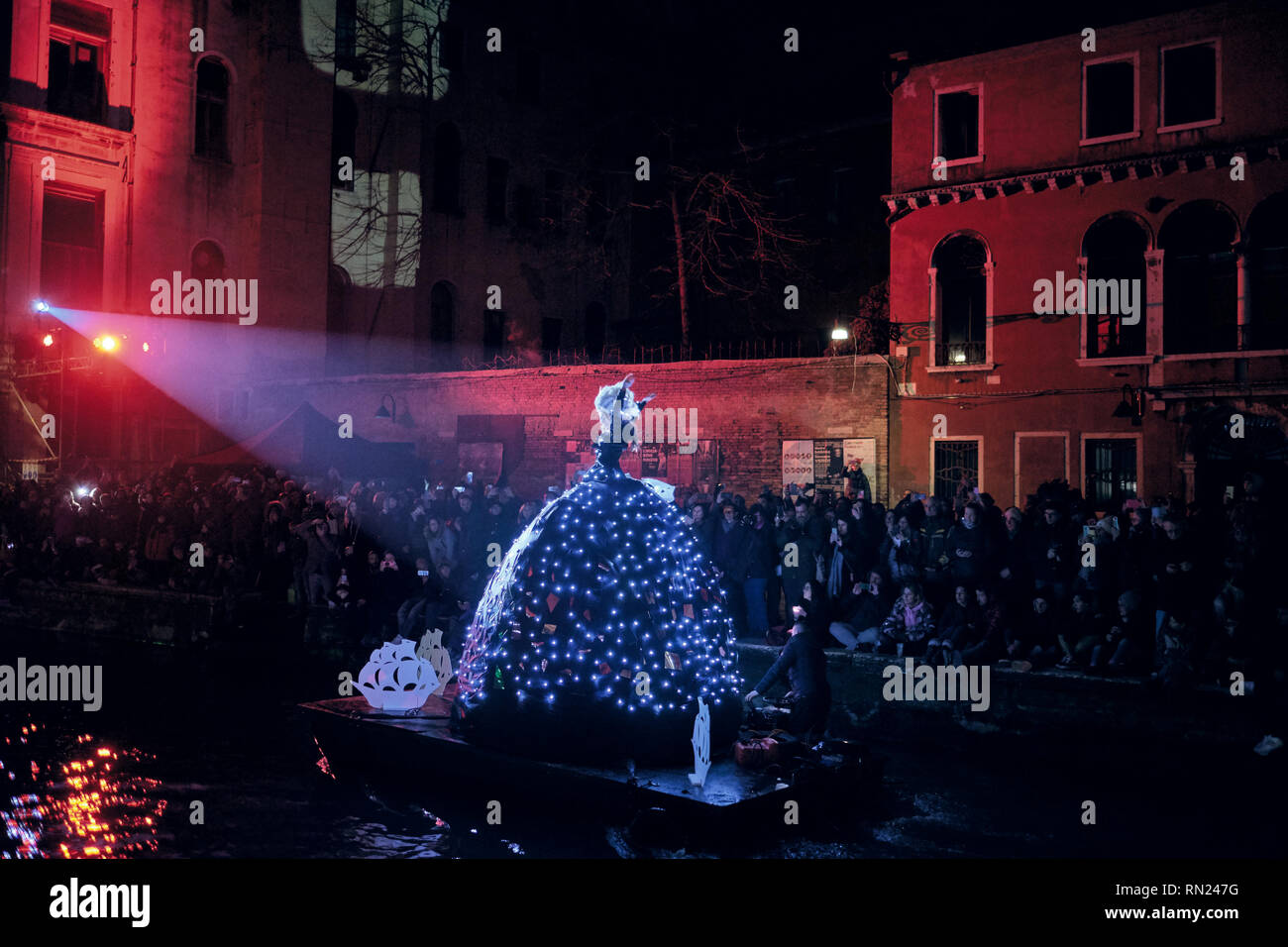Venecia, Italia. 16 Feb 2019. Multitud de personas que celebraban la apertura del Carnaval de Venecia. Bailarín con un traje iluminado en el desfile de agua. Crédito: Genciana Polovina/Alamy Live News Foto de stock