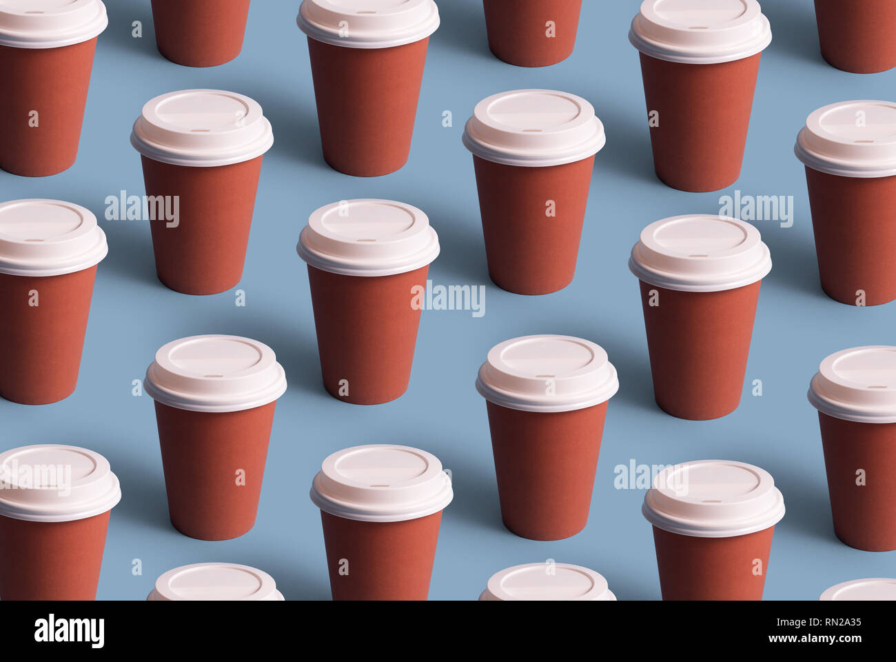 Tazas de café desechables organizadas en una fila sobre fondo azul. Foto de stock