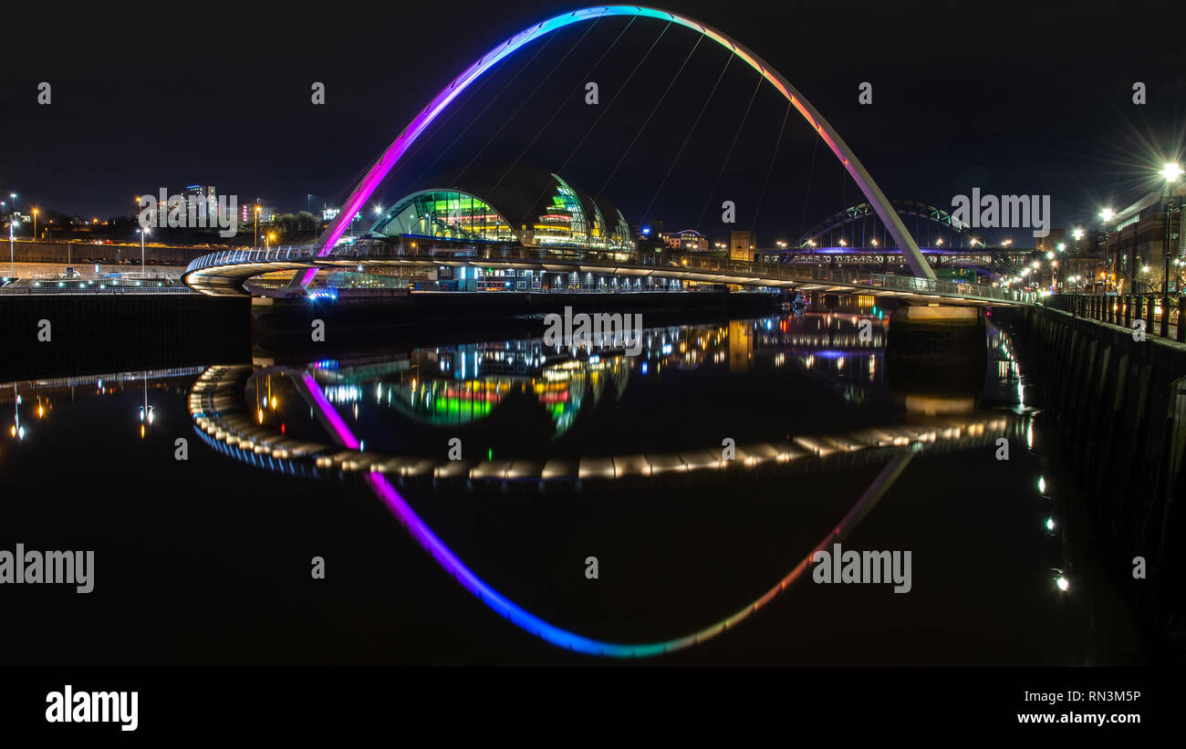 De Gateshead, Inglaterra, Reino Unido - Febrero 3, 2019: el puente del milenio de Gateshead se refleja en las aguas del río Tyne en la noche junto a la puerta de Salvia Foto de stock