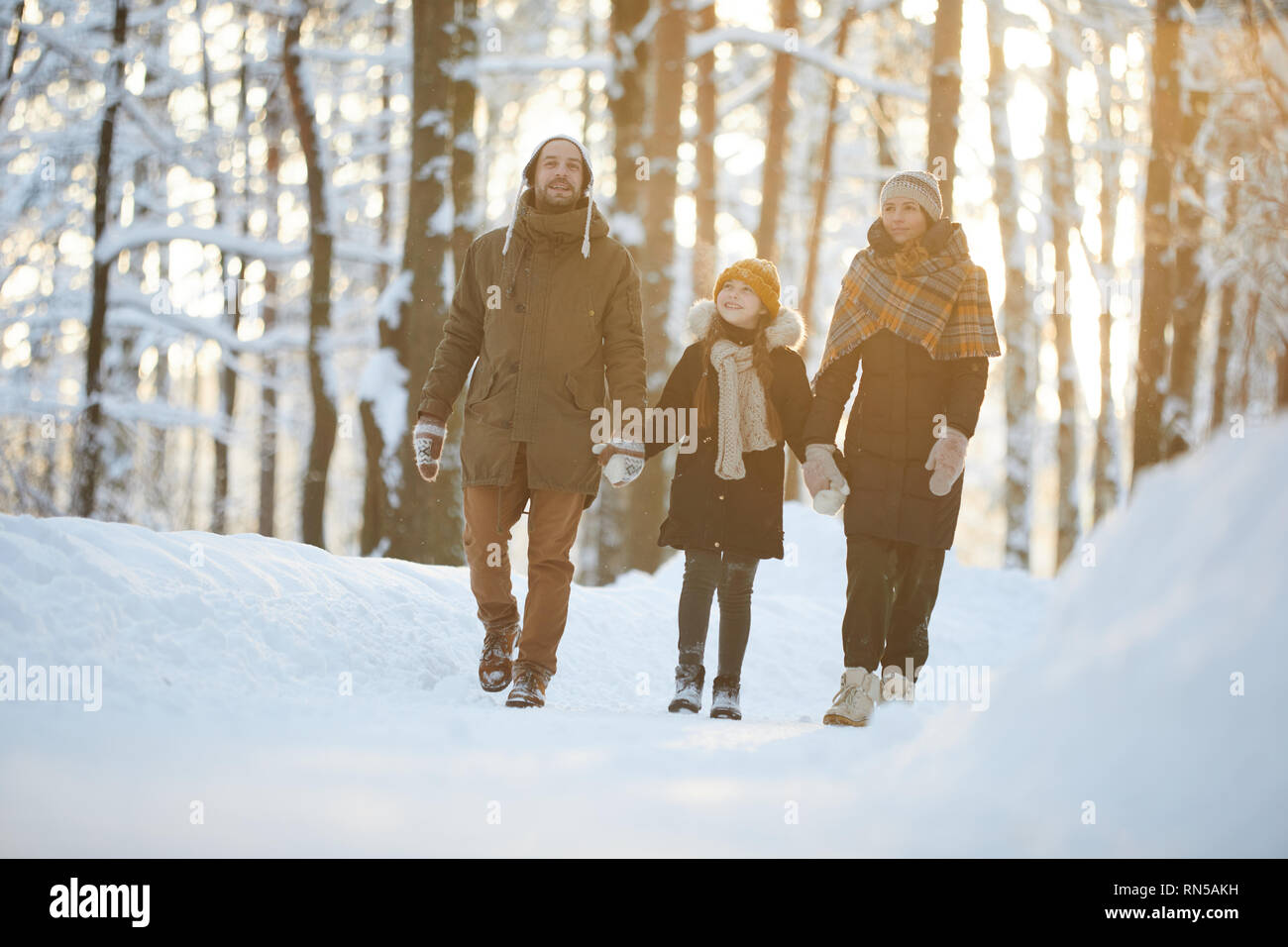 Familia Feliz disfrutando de caminata en bosque de invierno Foto de stock