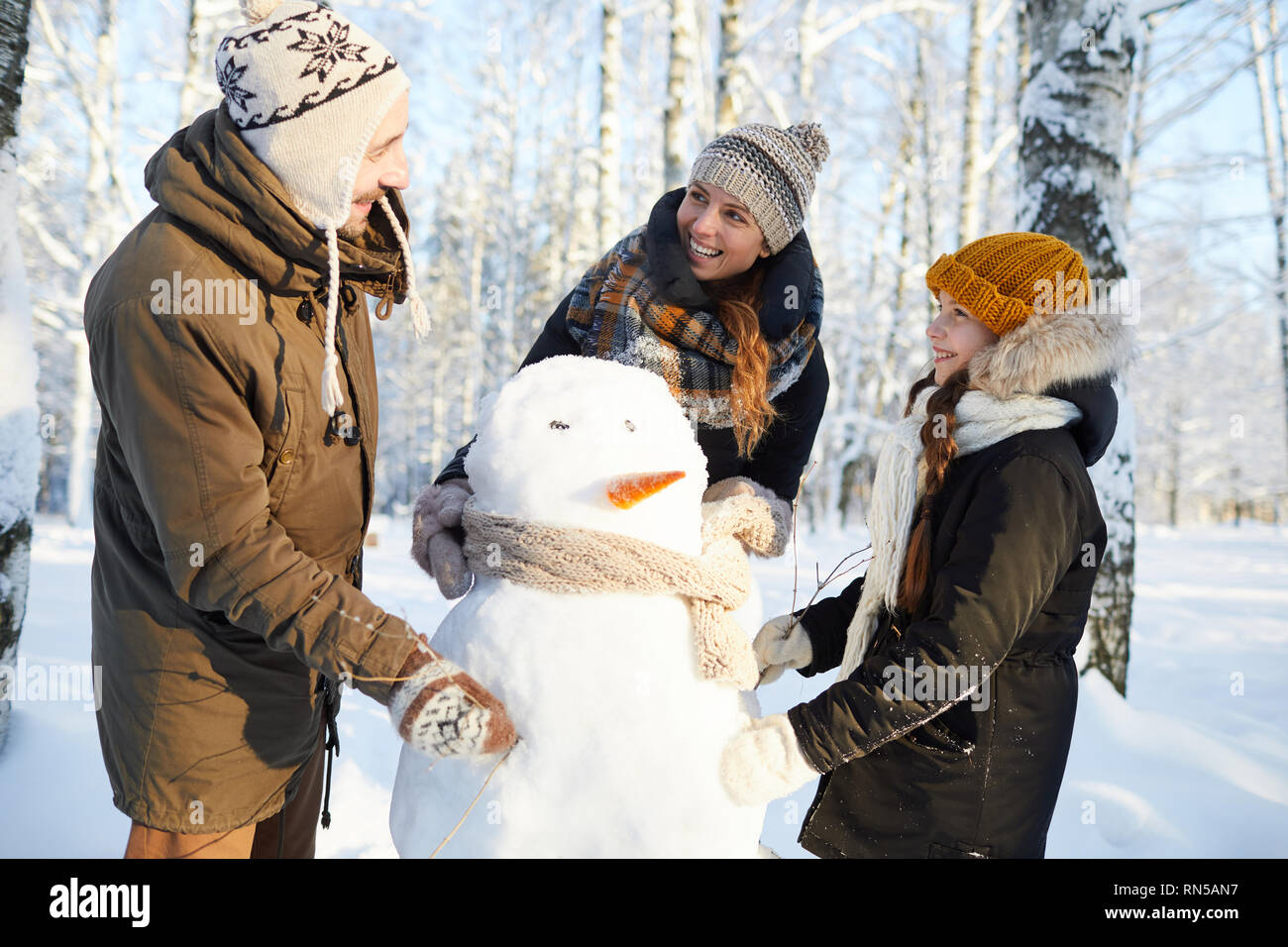 Familia Construyendo el muñeco de nieve Foto de stock
