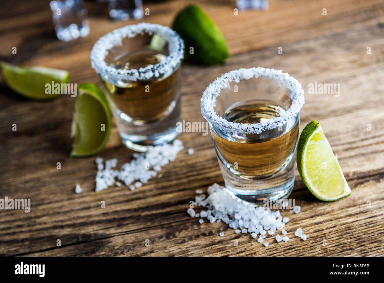 Beber alcohol tradicional mexicana tequila con limón y sal y el cubito de  hielo sobre la mesa de madera Fotografía de stock - Alamy