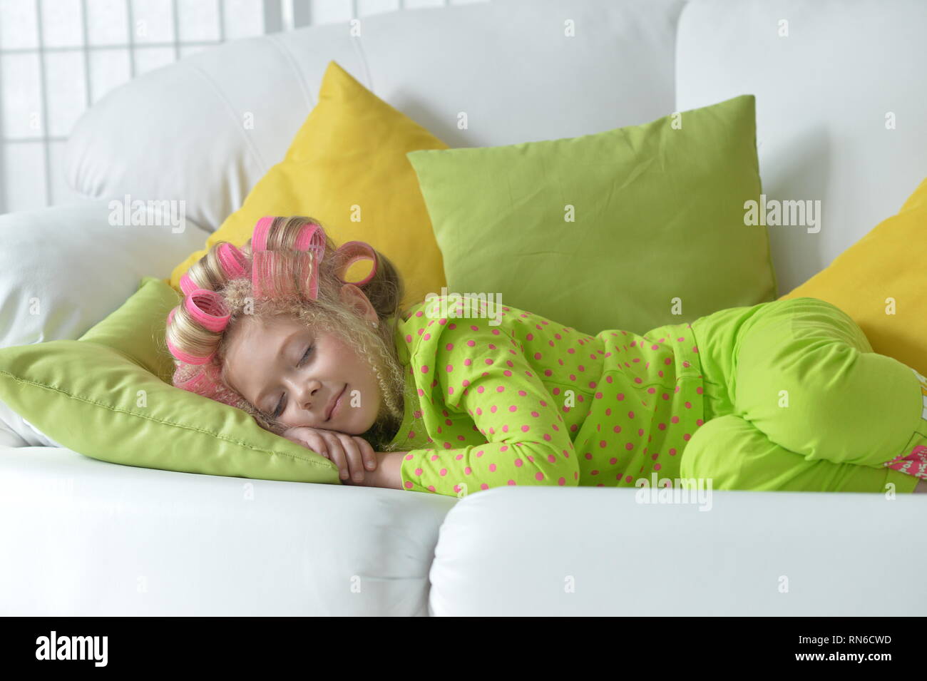Bonita niña con rulos rosa durmiendo Foto de stock
