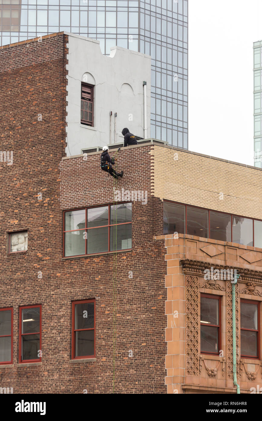Ingeniero Industrial descenso en rappel desde el lateral de un edificio en una inspección estructural, la ciudad de Nueva York, EE.UU. Foto de stock
