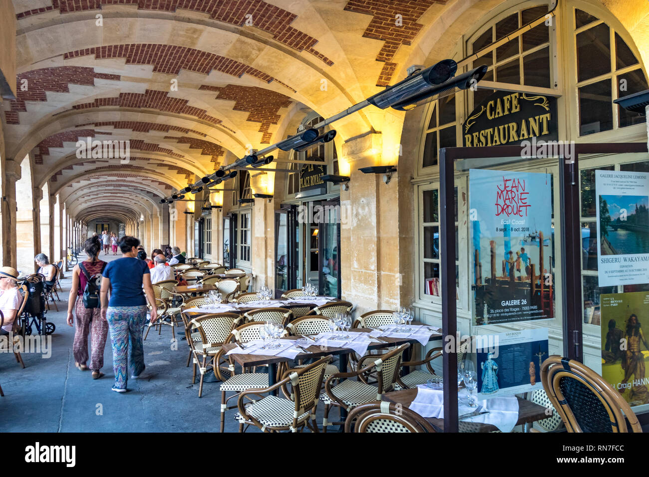 Un restaurante bajo las arcadas de la Place des Vosges, el Marais.Paris , una de las más bellas de la capital francesa Foto de stock
