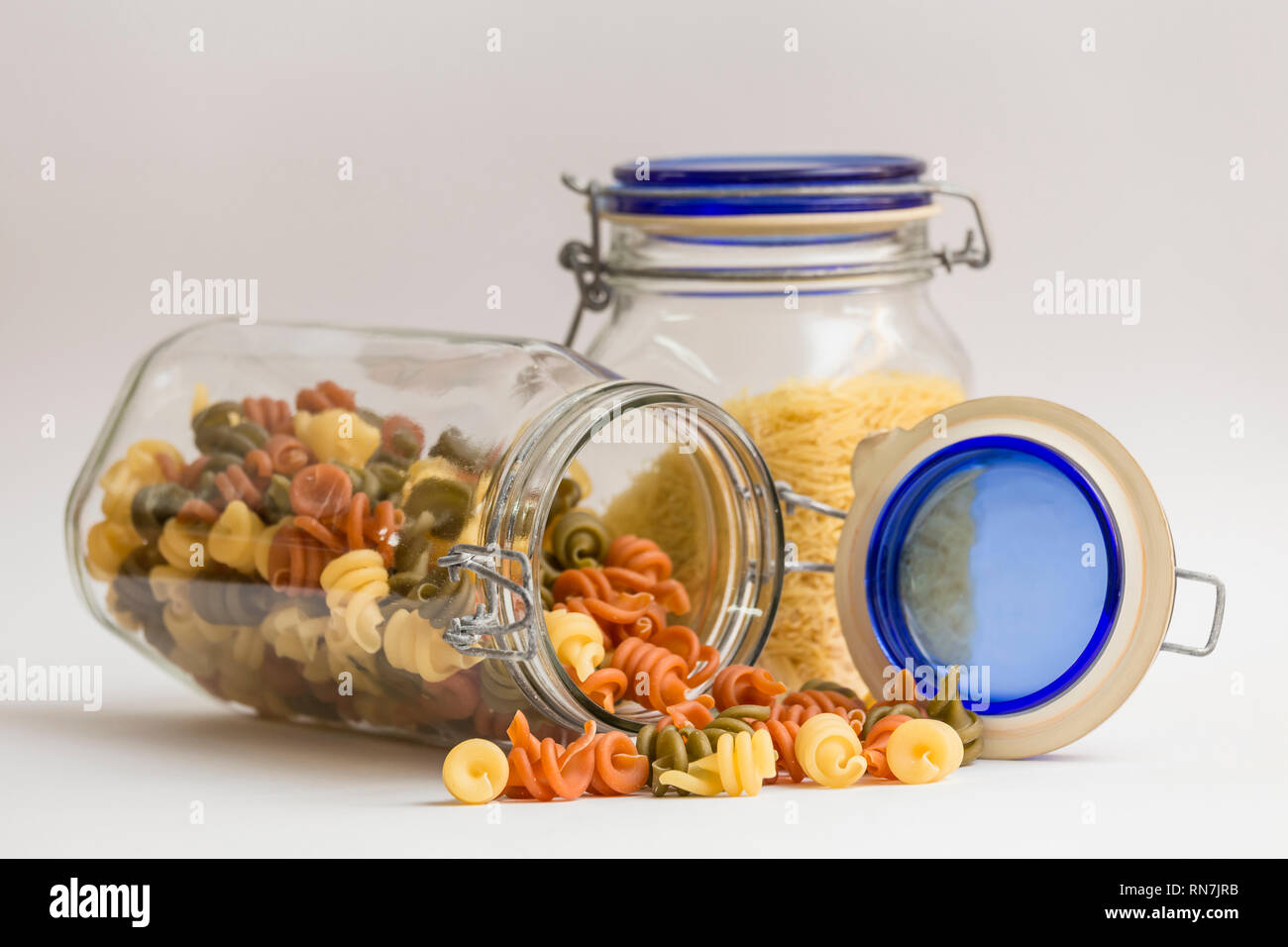 Frascos de vidrio para conservar alimentos, en uno de fideos y el otro una  pasta en forma de espirales de colores Fotografía de stock - Alamy