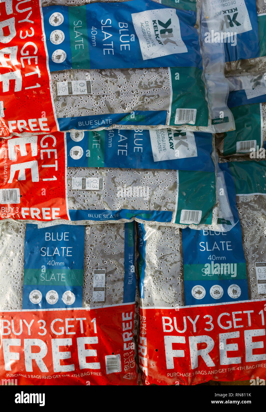 Visualización de bolsas de azul pizarra molida para jardín use Buy 3 get 1 Free oferta en un centro de jardinería Foto de stock