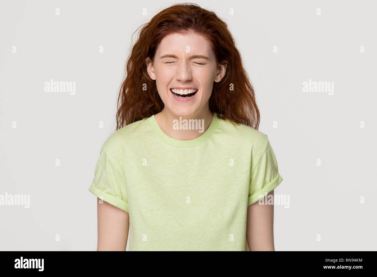 Feliz rojo-headed woman gritando con risas de fondo aislado Foto de stock