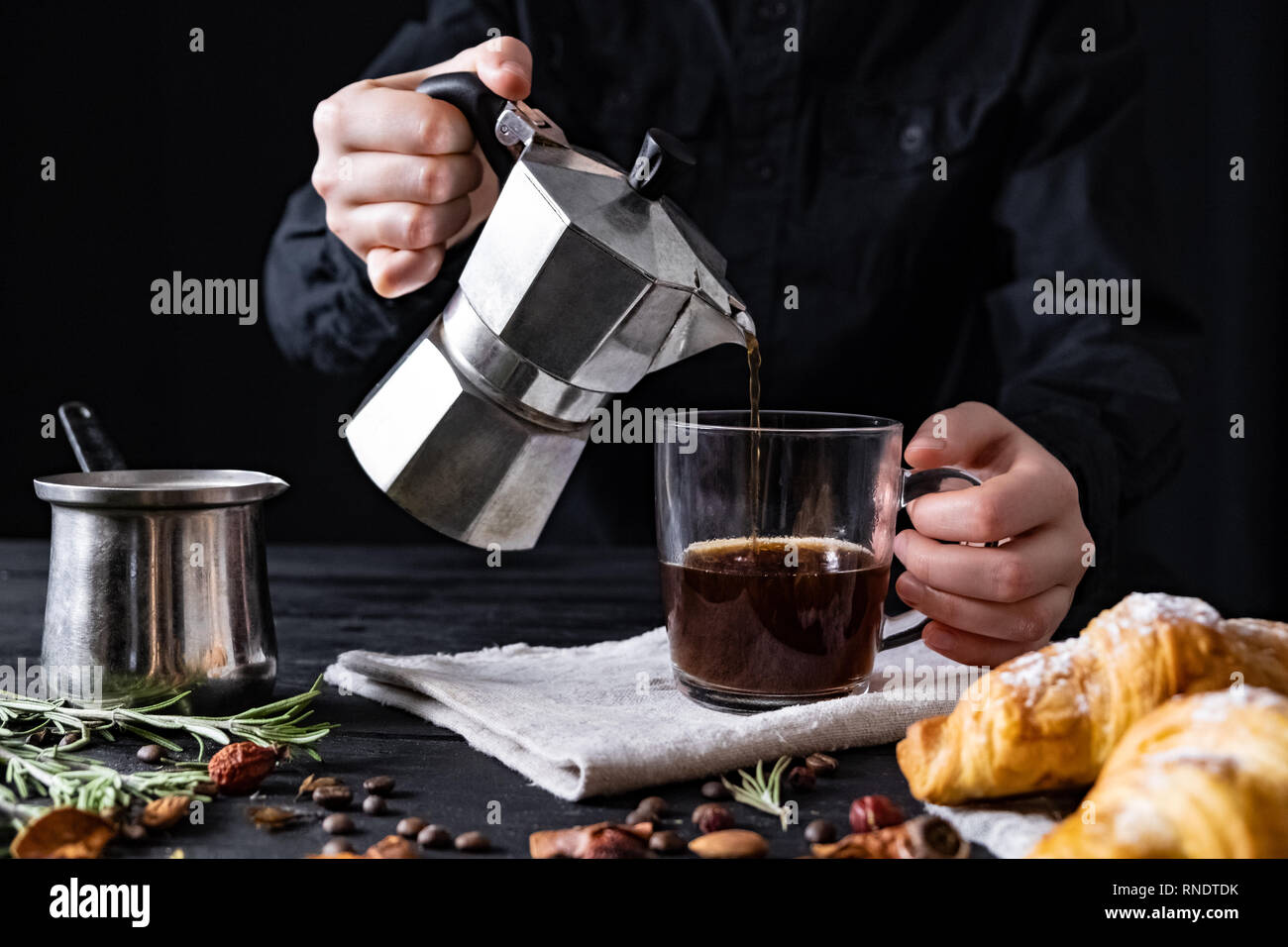 Verter el café de una cafetera eléctrica italiana, rodada en low key.  Vierta el café negro macho de manos de la italiana moka brewer Fotografía  de stock - Alamy