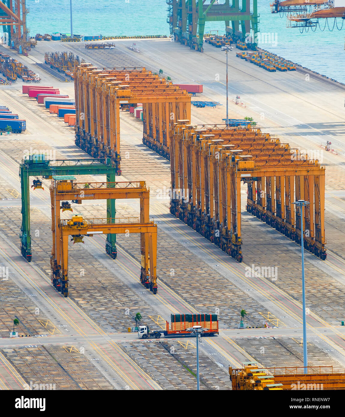 Equipos industriales, grúas de carga y construcciones de acero en el muelle en el puerto de embarque de carga vacía de Singapur, vista aérea Foto de stock