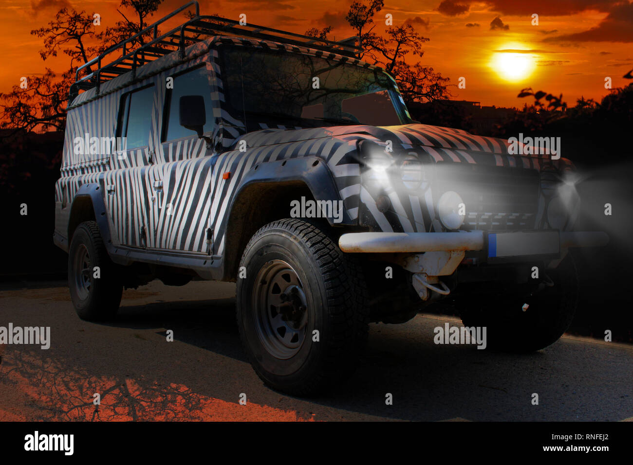 Safari Jeep con un patrón de cebra unidades mediante un savana seco y caliente de la naturaleza de África Foto de stock