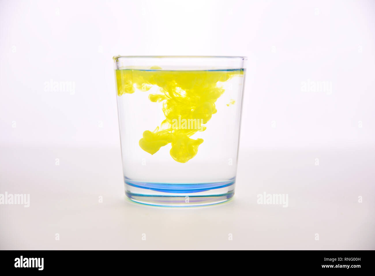 Vaso con agua sobre un fondo blanco con pintura amarilla ...