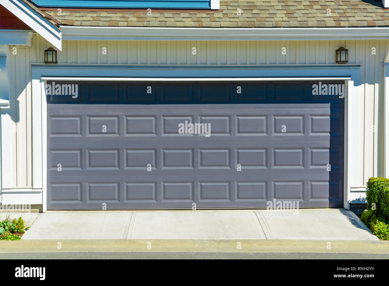Nueva casa residencial con entrada y puertas de garaje enfrente de día  soleado Fotografía de stock - Alamy