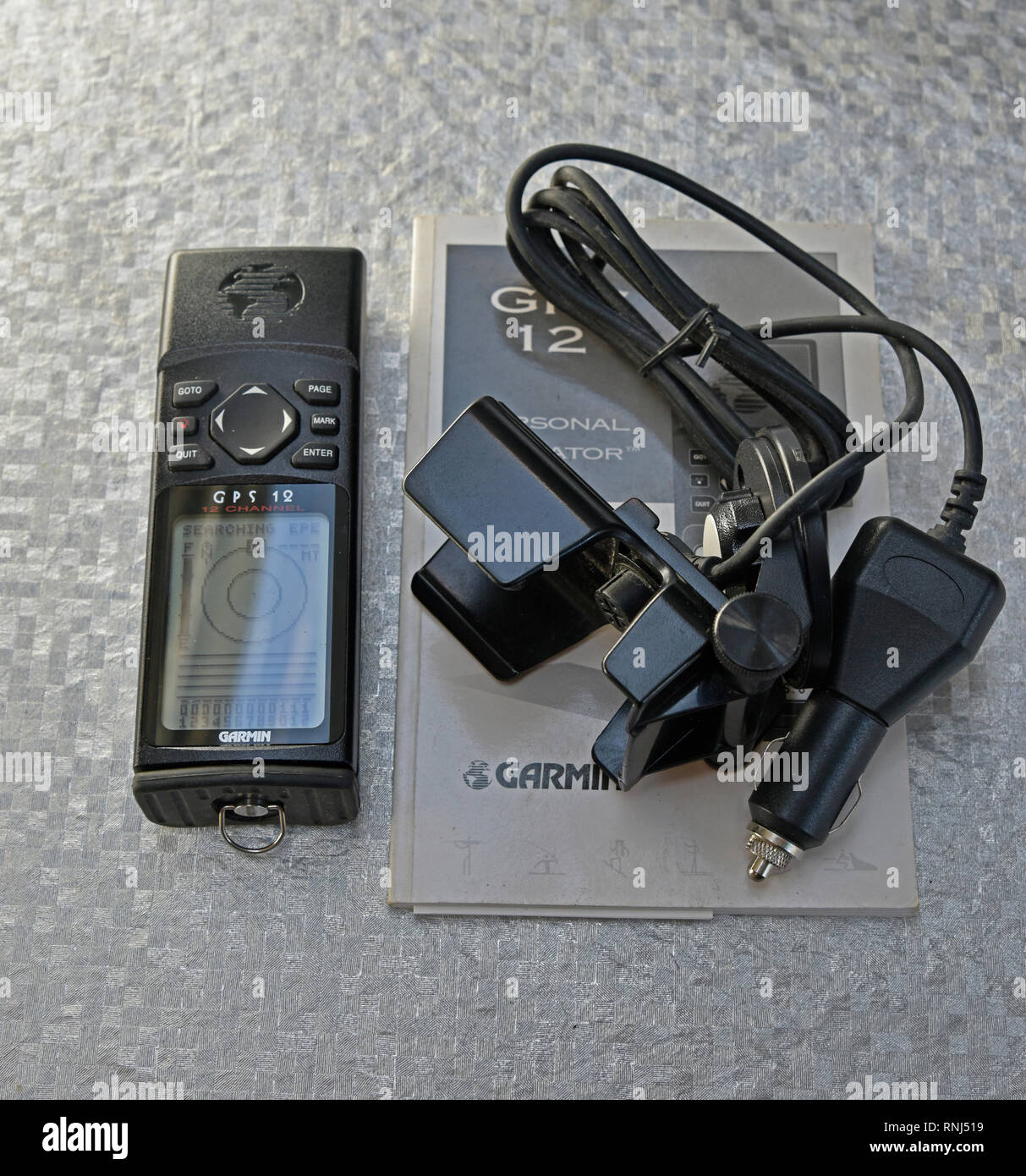 Garmin GPS 12 completa con manual de instrucciones en inglés y coche de 12v  y el cable de alimentación y el tablero soporte titular sobre el fondo liso  Fotografía de stock - Alamy