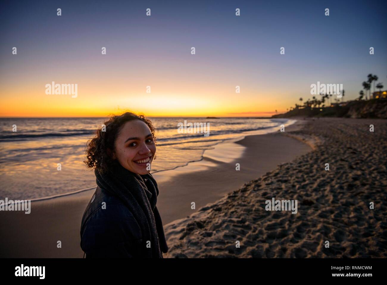 Mujer joven en la playa al atardecer, Laguna Beach, en el condado de Orange, California, EE.UU. Foto de stock