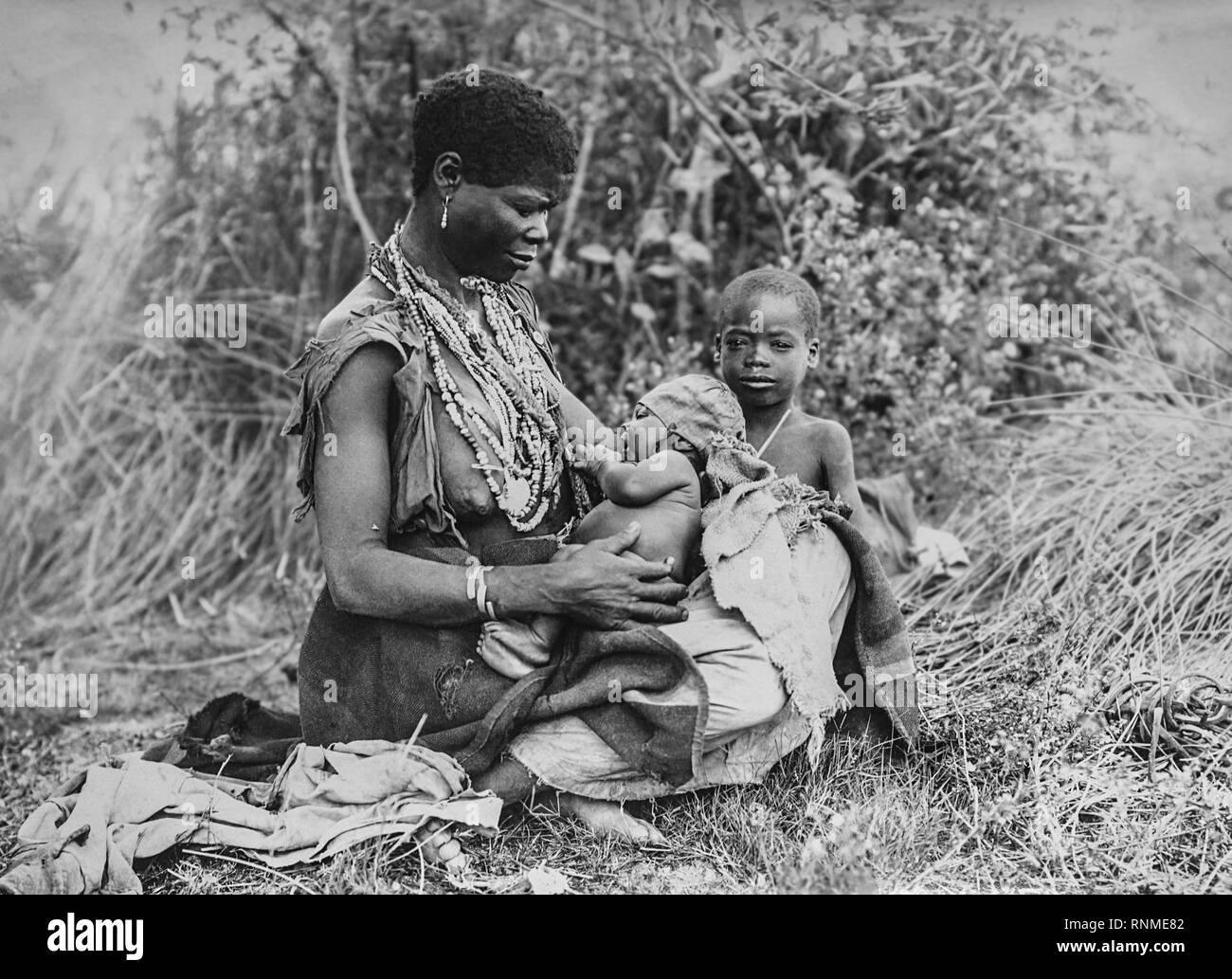 Mujer africana con dos niños al aire libre de 1916, Durban, Sudáfrica Foto de stock