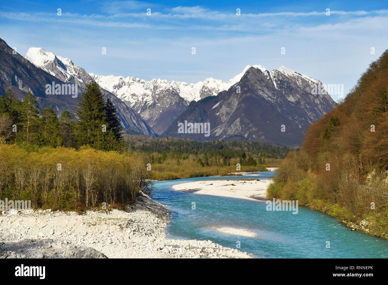 Río de montaña Soca, detrás de las montañas cubiertas de nieve, Bovec Kanin, Soca Valley, Alpes Julianos, Eslovenia Foto de stock