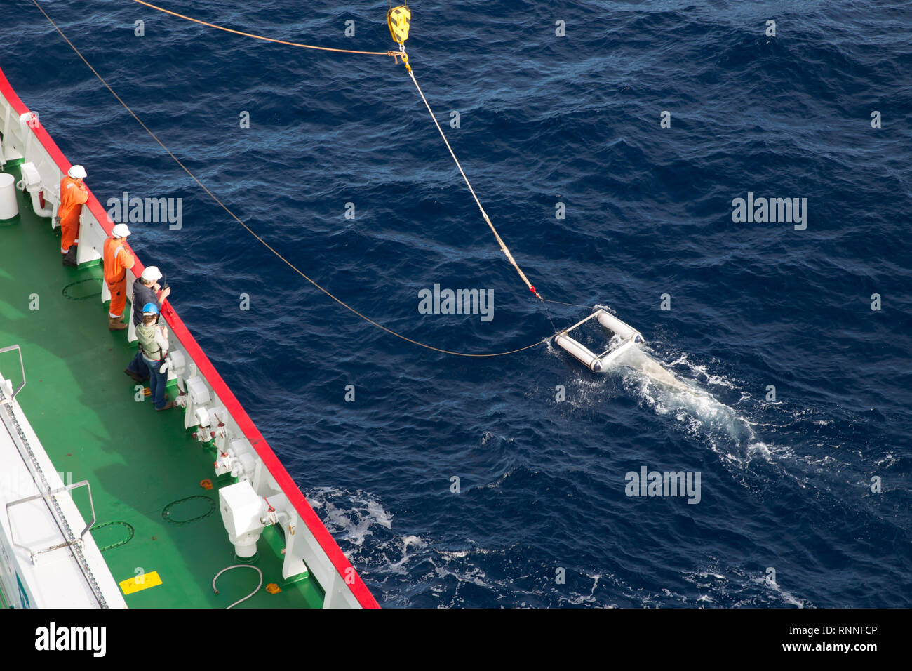 Un buque de investigación oceanográfica científicas realiza un crucero en el Océano Atlántico Sur por remolcar un Neuston net para muestrear microplastic contaminación. Foto de stock