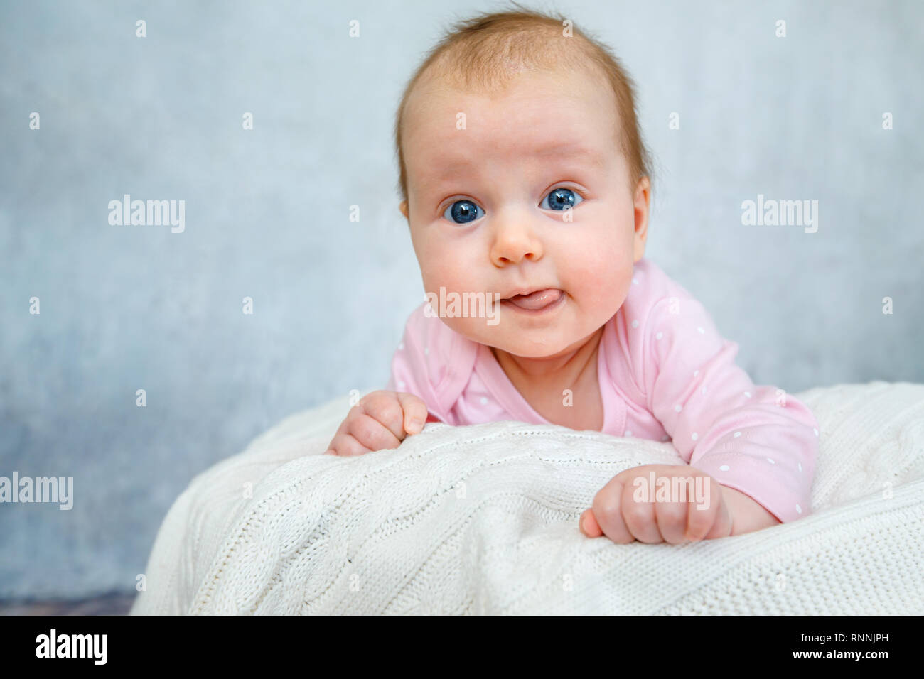 Retrato de un lindo bebé recién nacido recostado sobre su estómago Foto de stock
