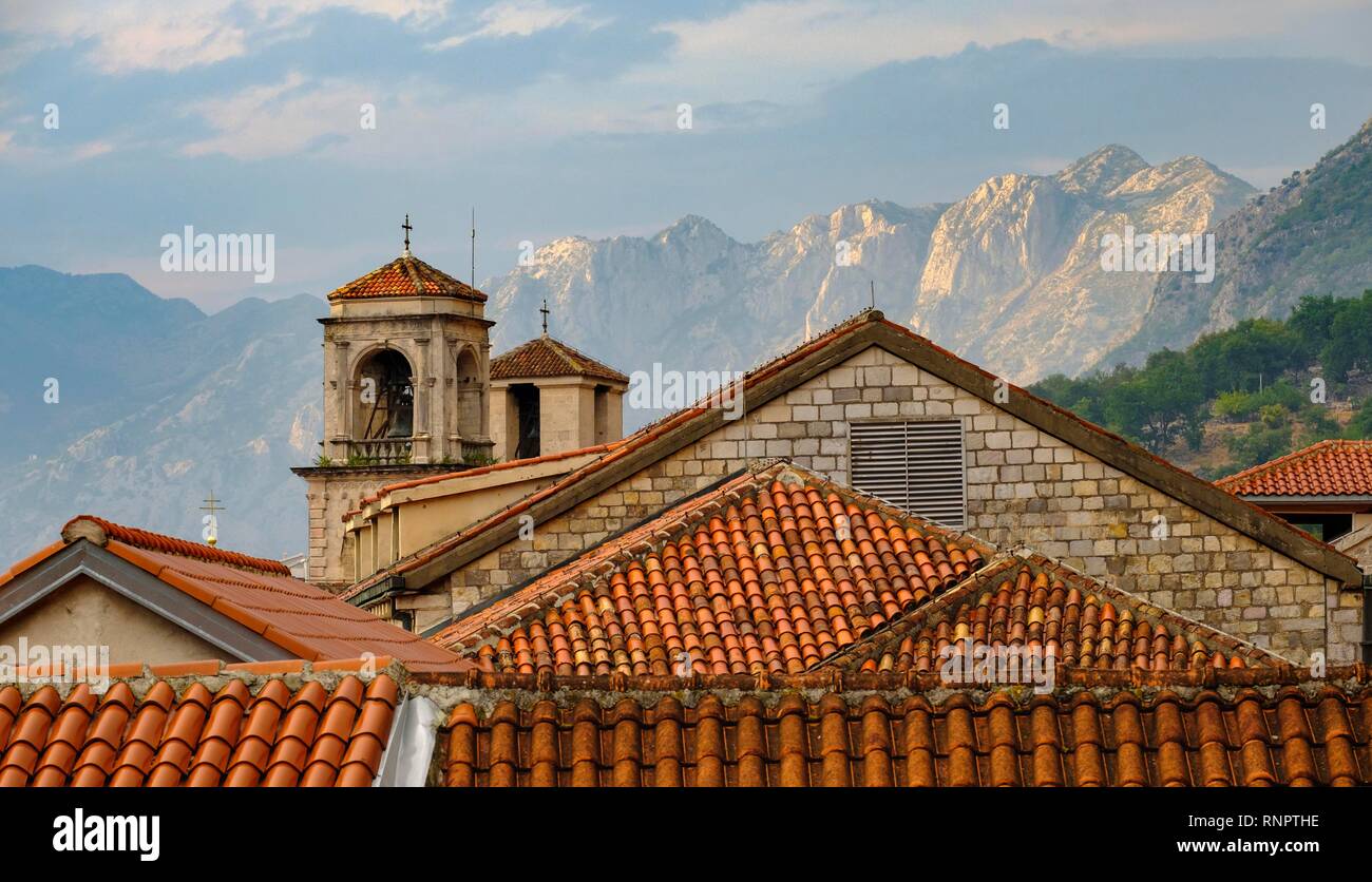 Los tejados del casco antiguo de la ciudad con las torres de la catedral en frente de las montañas, Kotor, Montenegro Foto de stock
