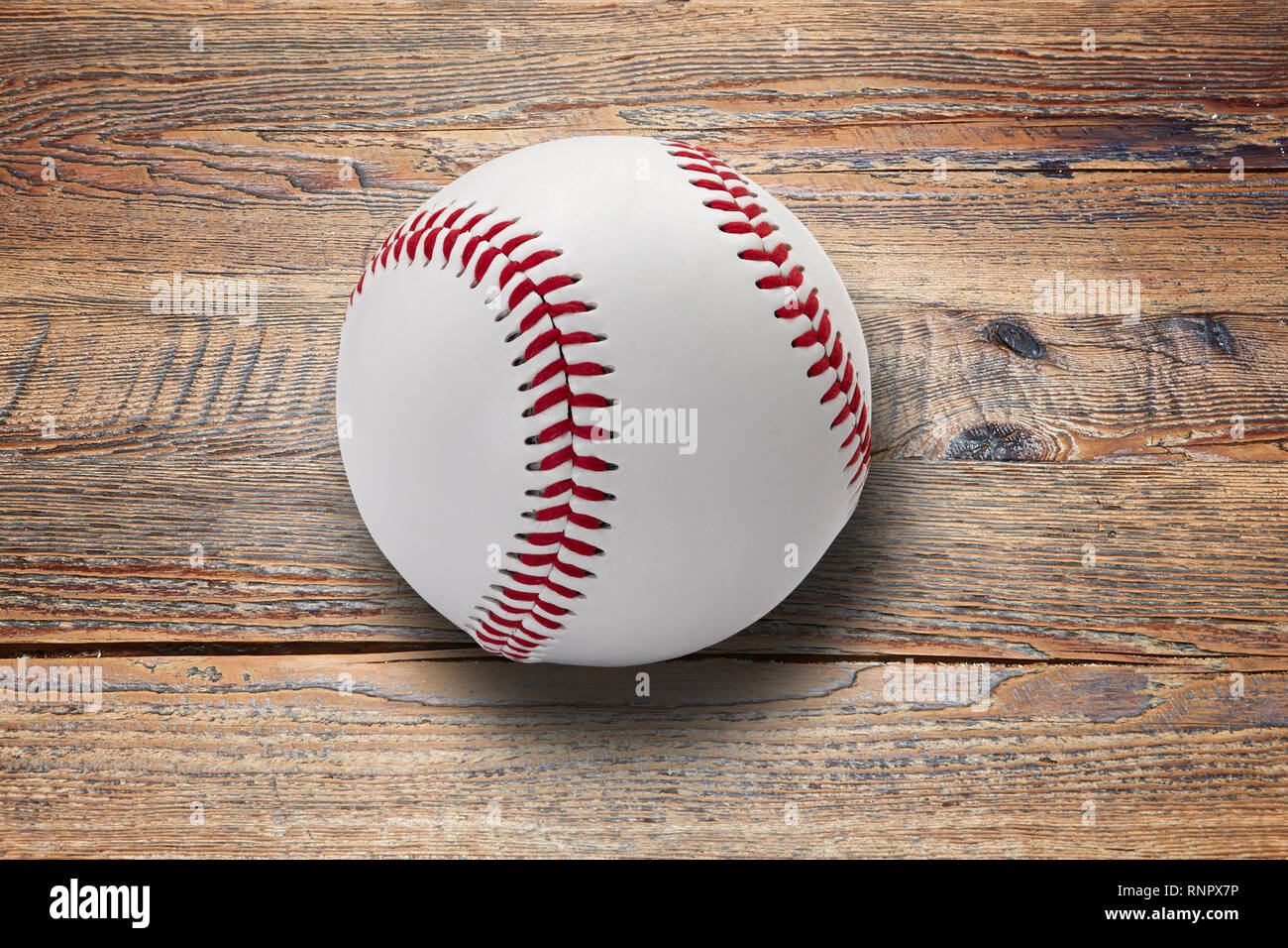 Pelota de béisbol en la mesa de madera marrón texturizado con espacio de copia Foto de stock