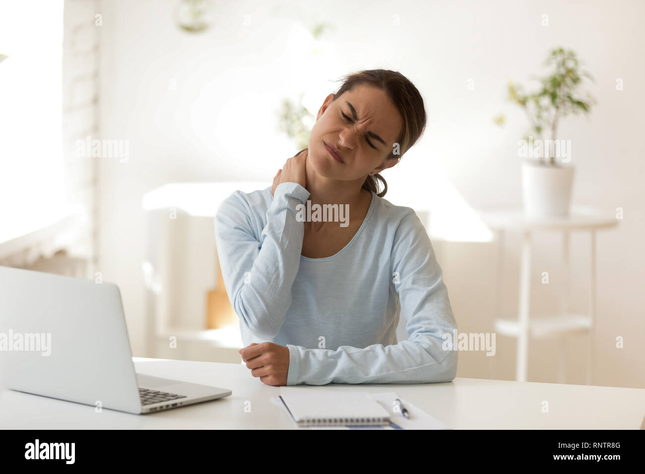 Las hembras jóvenes sufre de dolor de cuello en el lugar de trabajo Foto de stock