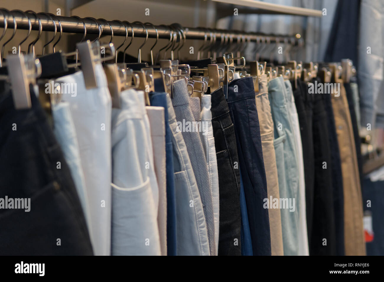Fila de pantalones vaqueros y en las estanterías en la tienda de ropa,  tiendas. Fondo desenfocado con la tienda de ropa interior. Tienda de ropa,  nadie Fotografía de stock - Alamy
