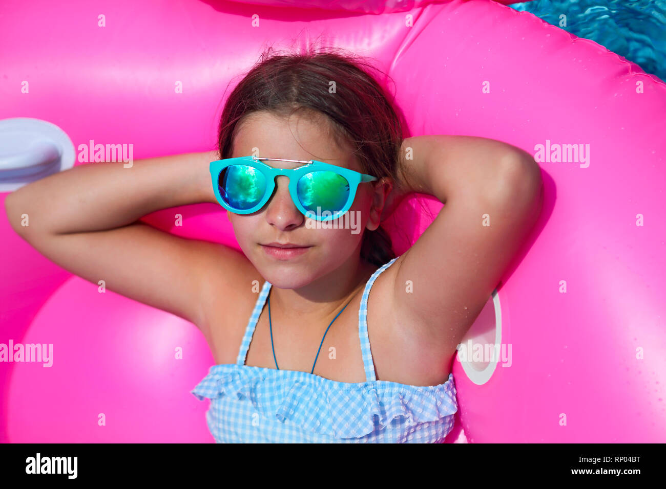 Retrato de niña con gafas de sol en flamingo inflable nadar flotar,  disfrutando de la piscina en verano Fotografía de stock - Alamy