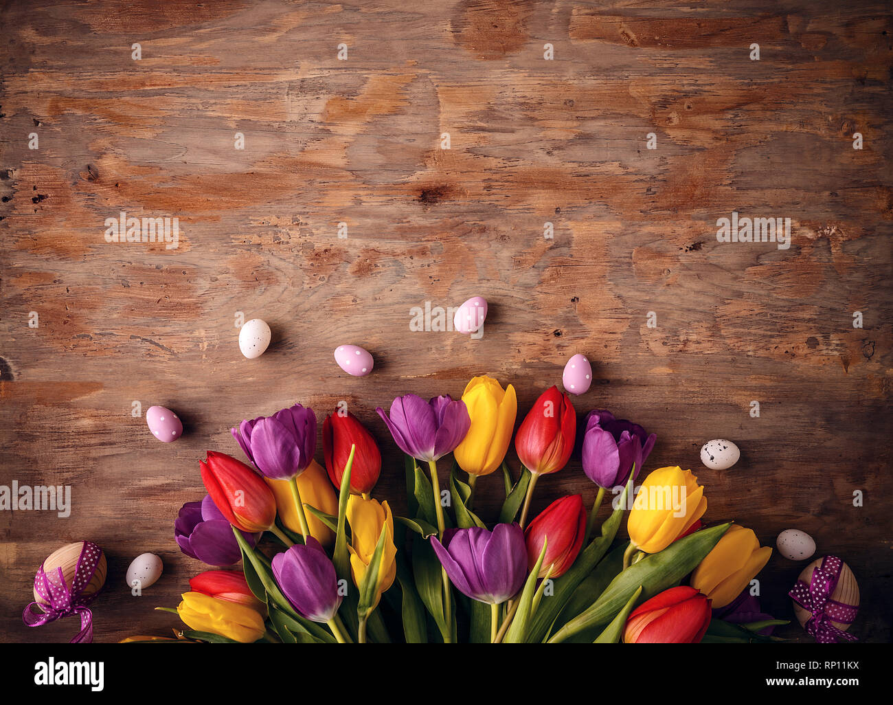 Fondo de vacaciones de Pascua con huevos y flores sobre fondo de madera, espacio de copia Foto de stock