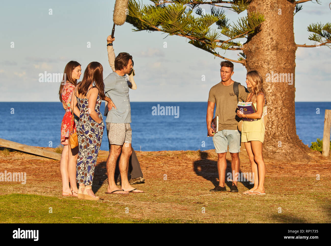Actores y una barra de sonido operador filmando una escena al aire libre de la casa y fuera del programa de televisión en el Palm Beach, New South Wales, Australia Foto de stock