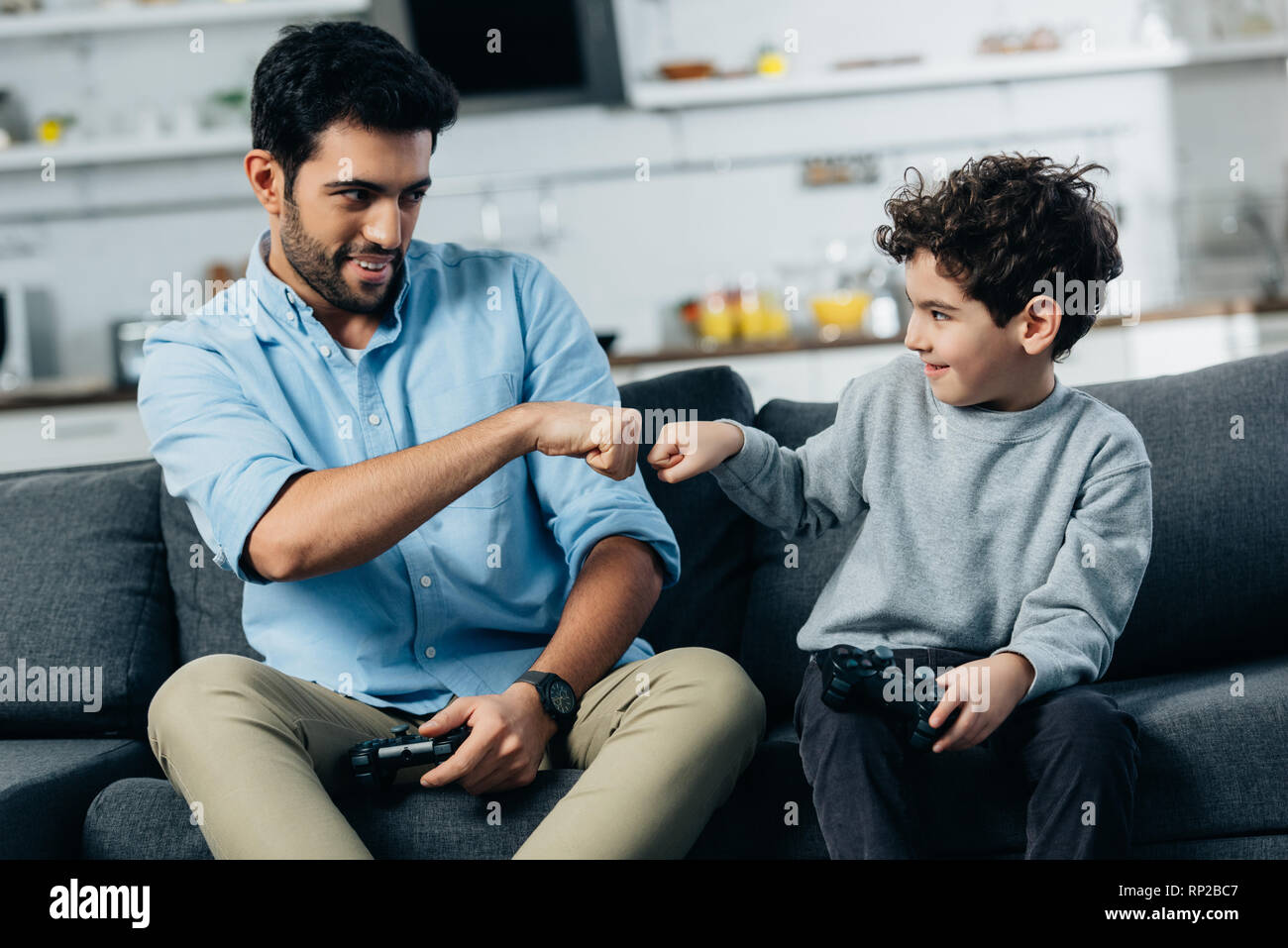 Alegre América padre dando puño golpee a hijo tras jugar video juego en casa Foto de stock