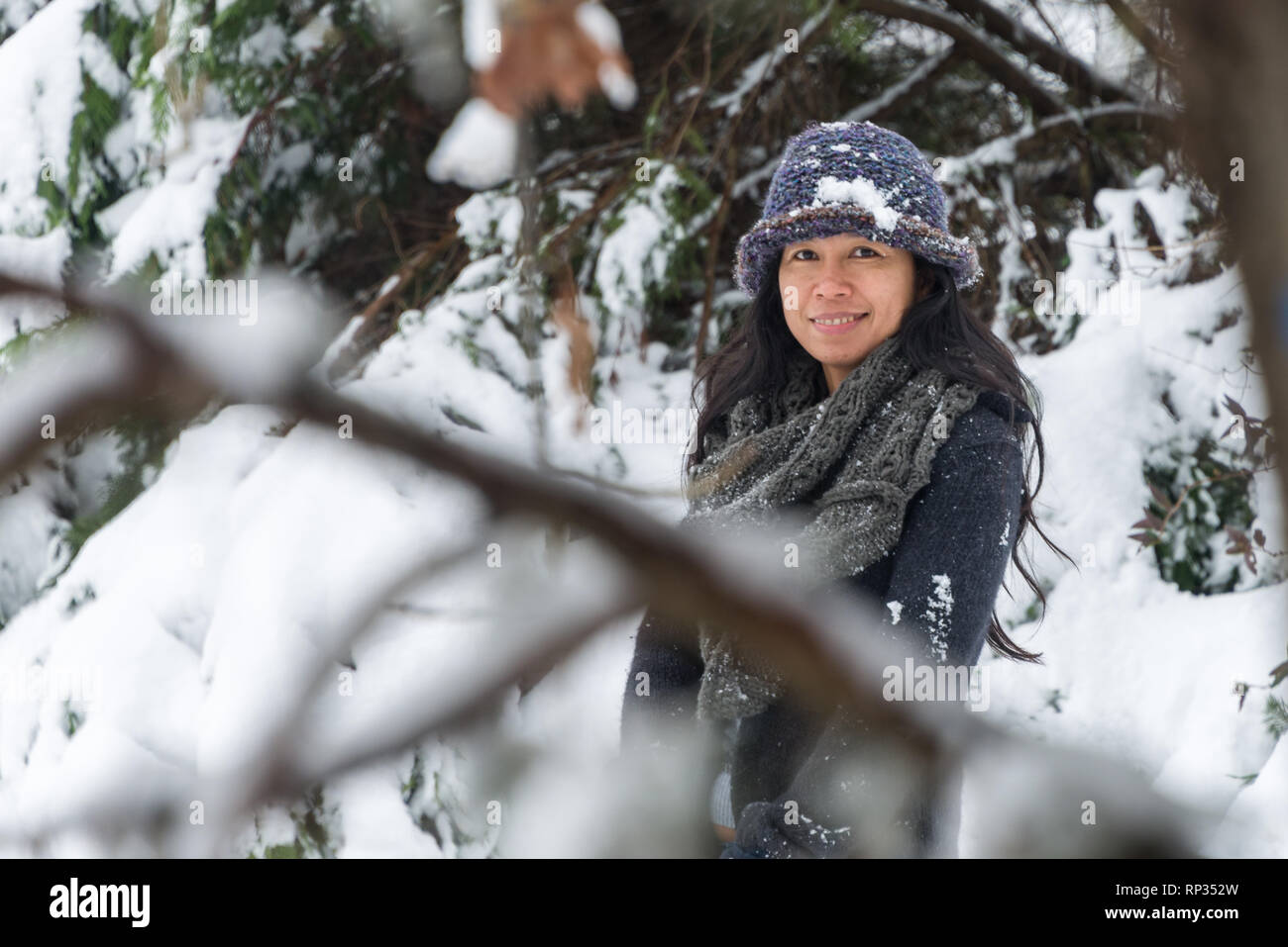 Mujer joven con estilo vistiendo ropa de abrigo tocando la nieve y