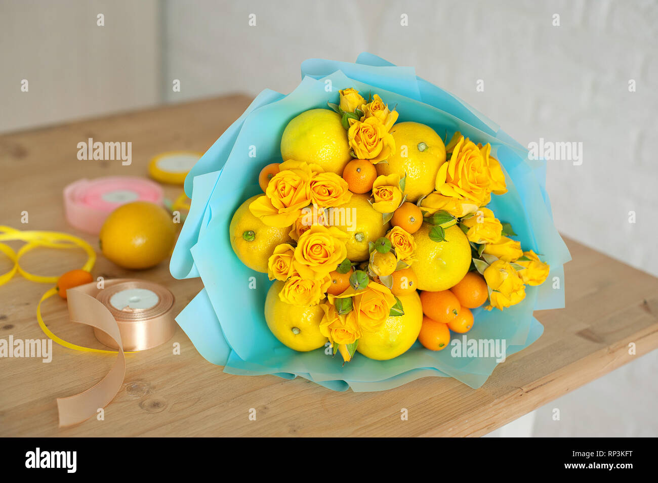 Bouquet de flores y frutas. composición sobre un fondo de madera Foto de stock