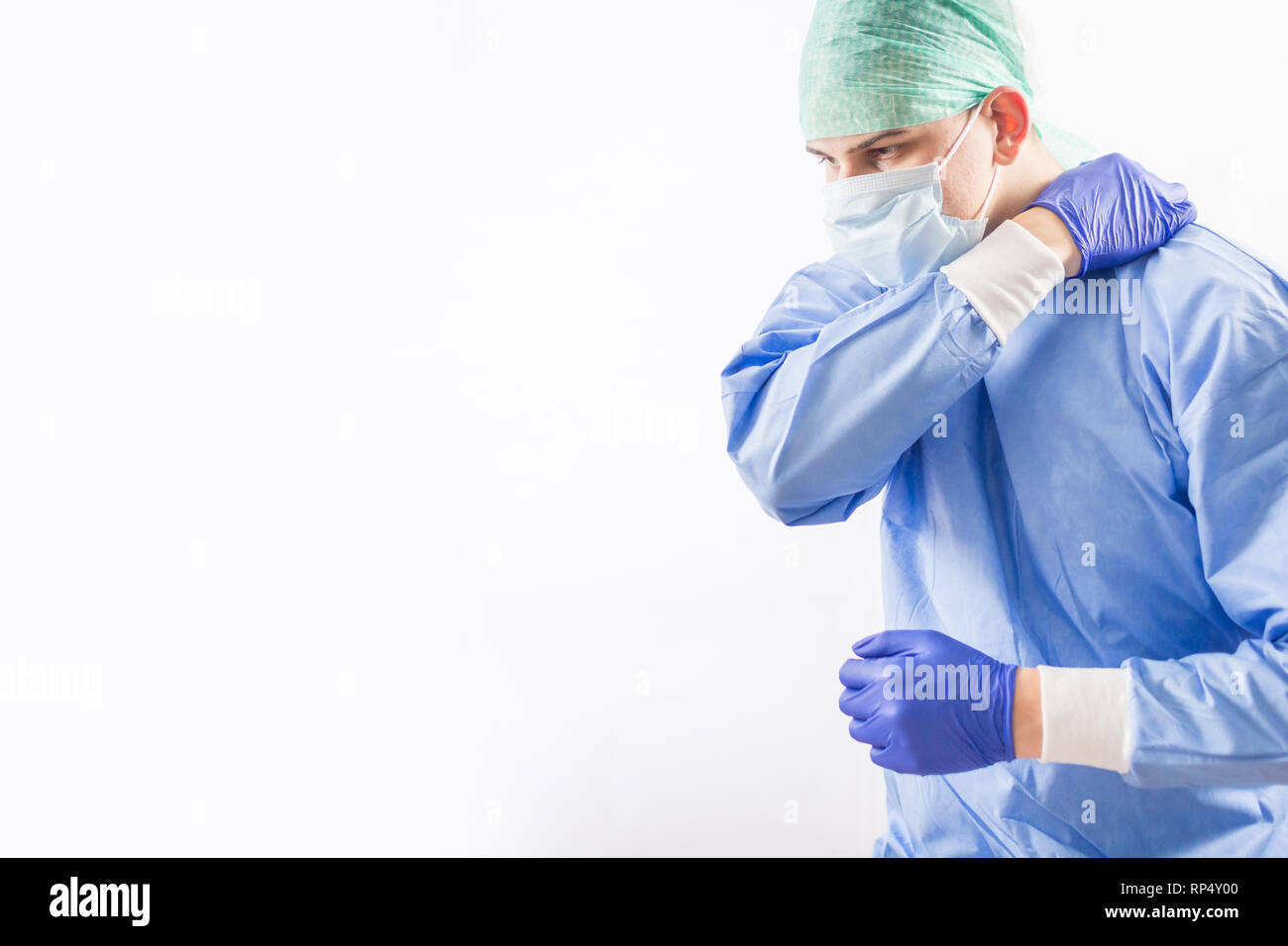 Médico cirujano guantes estériles en preparación para el funcionamiento en  el hospital. Él está usando la tapa quirúrgica y bata azul Fotografía de  stock - Alamy