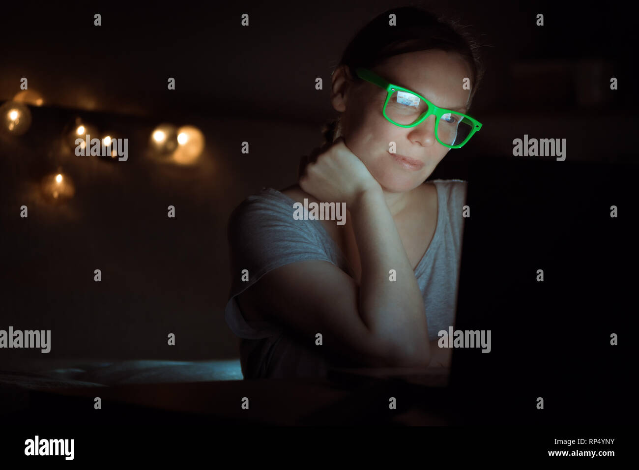 Mujer trabajando horas extraordinarias en un portátil a altas horas de la noche, low key retrato de mujer emprendedora en entornos de oficina doméstica Terminar tarea empresarial Foto de stock