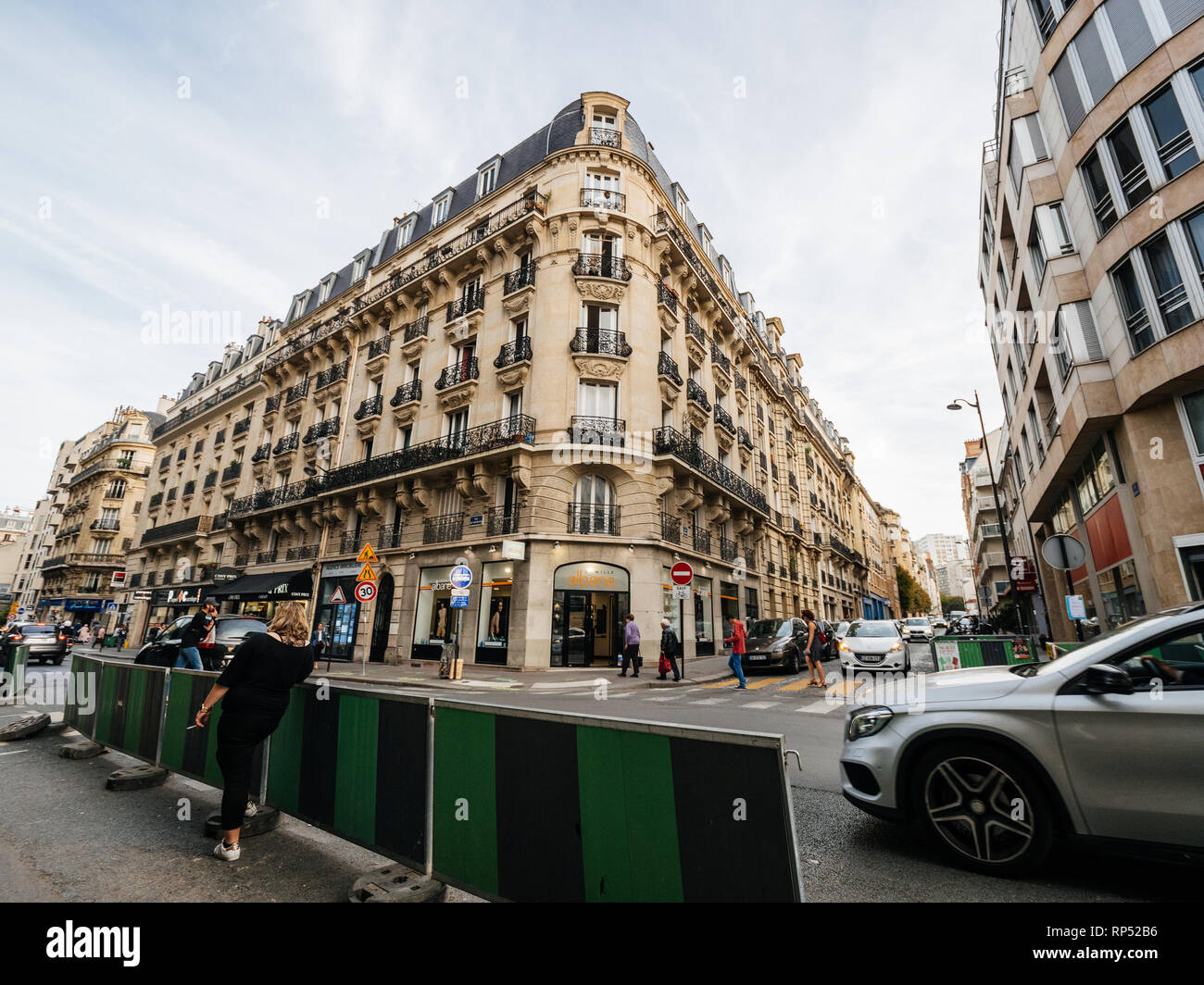 París, Francia - 13 Oct, 2018:Mujer fumando en la esquina de la calle con Hausmannian edificio del fondo Foto de stock