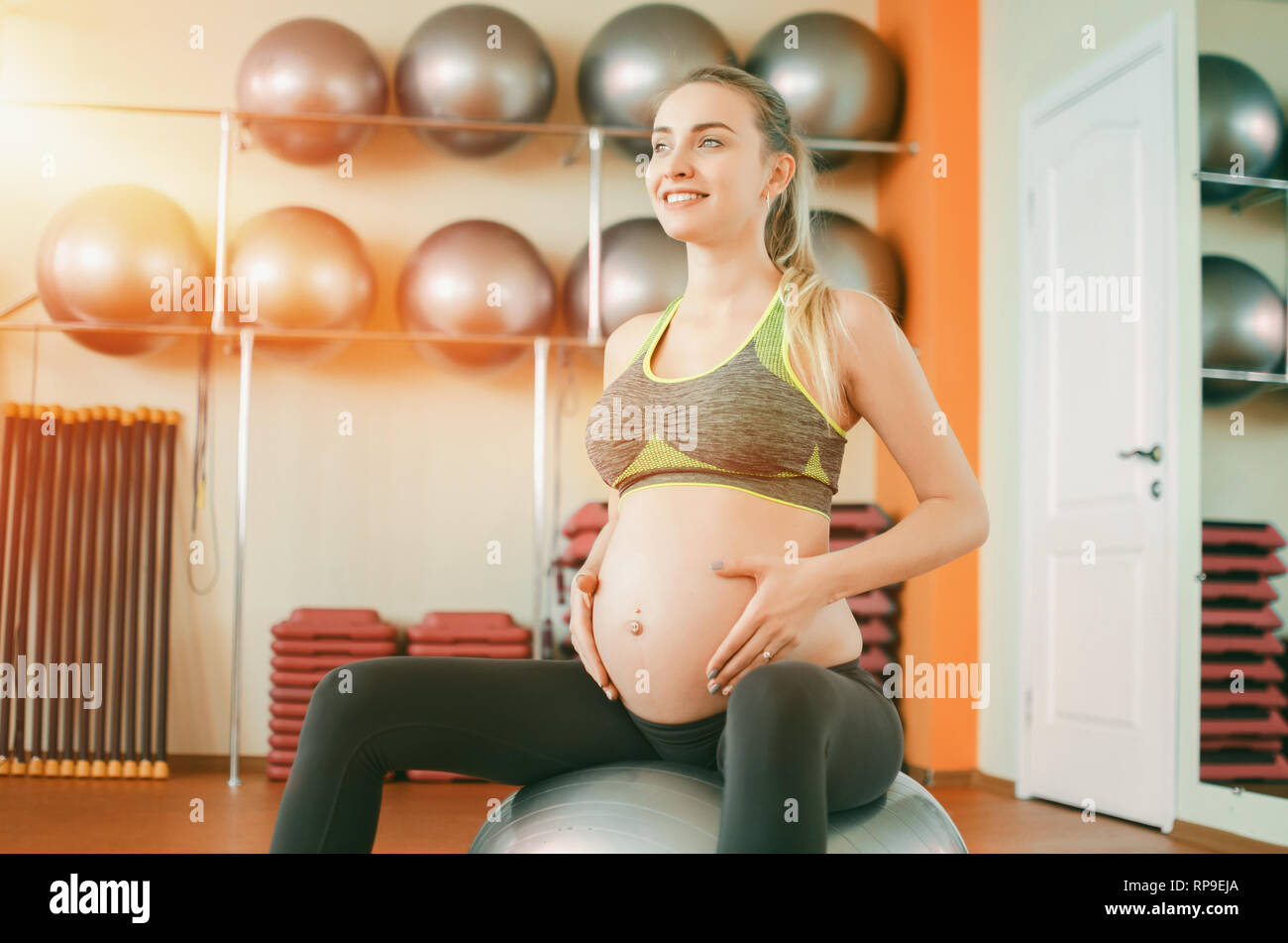 Yoga para mujeres embarazadas. Hermosa joven niña embarazada en ropa  deportiva Hacer yoga sobre fitball Fotografía de stock - Alamy