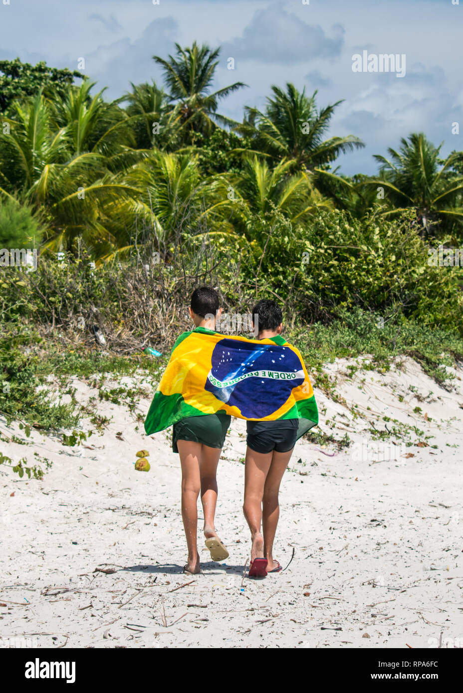 Dos chicos en la playa envuelto alrededor de una toalla con una bandera  brasileña imprimir Fotografía de stock - Alamy
