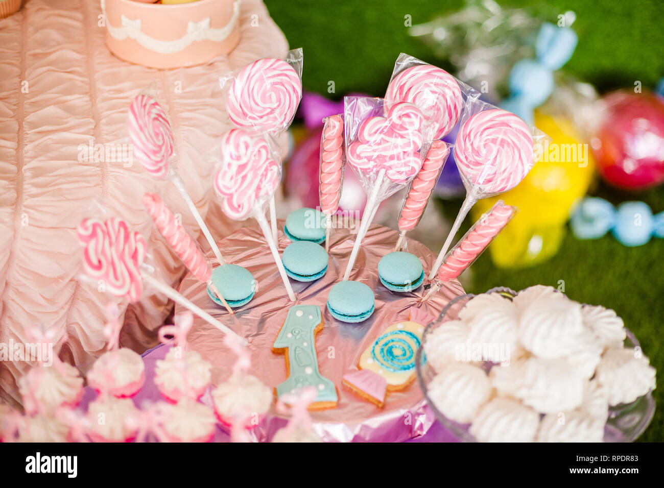 Barras de caramelo para el primer cumpleaños de bebé niña o niño. Mesa dulce  y agradable rosa y azul galletas en rosa, blanco mesa malvaviscos y una  rosa Fotografía de stock -