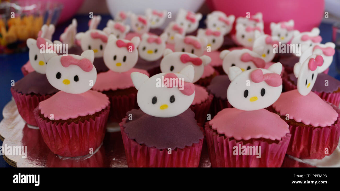 Pastelitos para fiestas infantiles en violeta y rosa con cara de gato  Fotografía de stock - Alamy