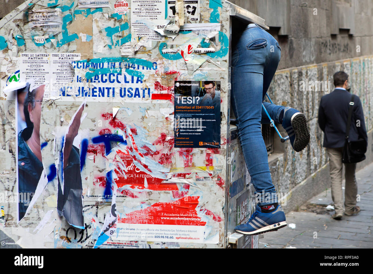 Nápoles - un muchacho es hurgando en bolsas de basura en el centro histórico de Nápoles. Foto de stock