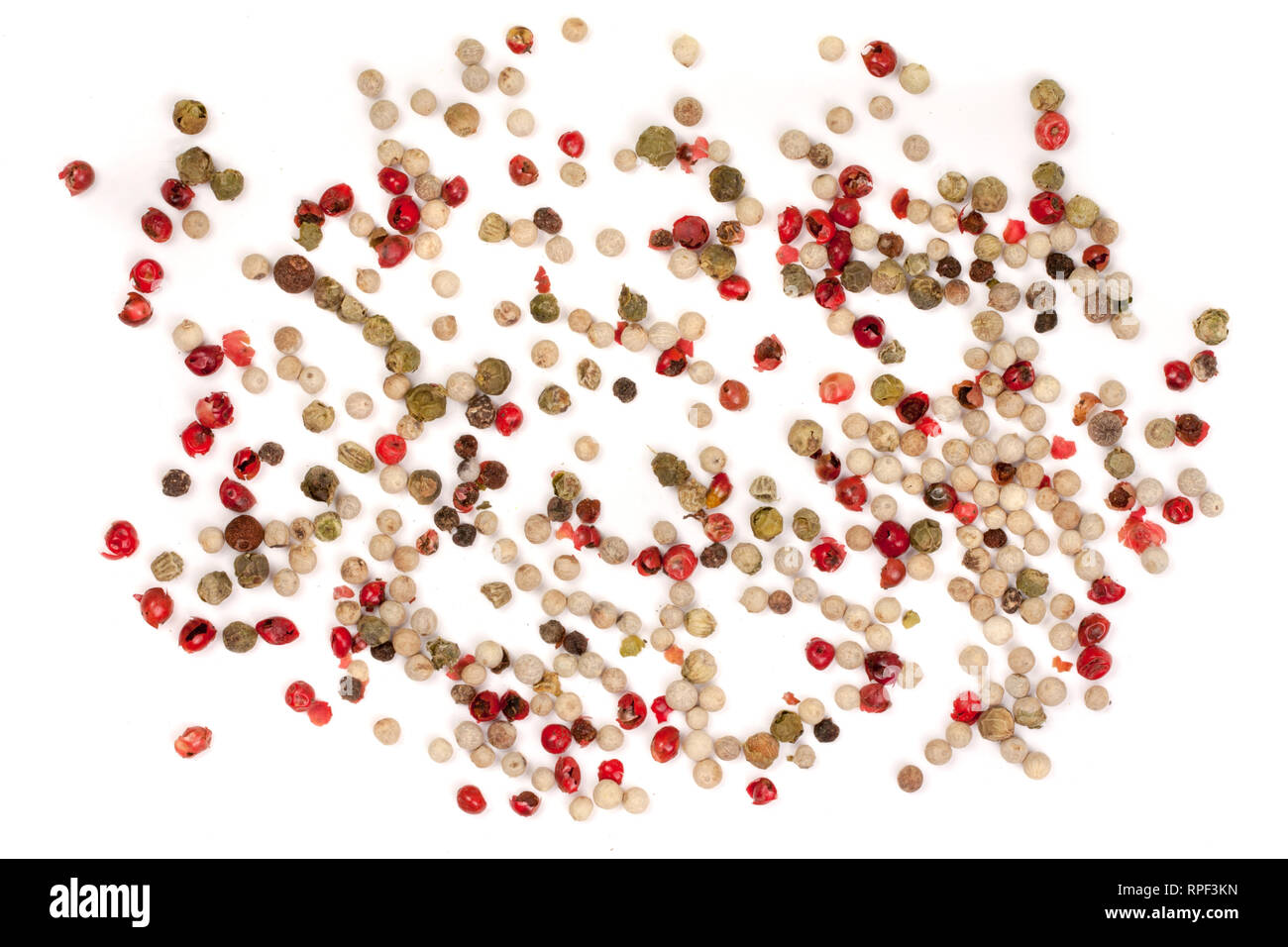 Negro, rojo, verde, granos de pimienta blanca aislado sobre fondo blanco. Montón de especias. Mezcla de diferentes chiles. Vista superior Foto de stock