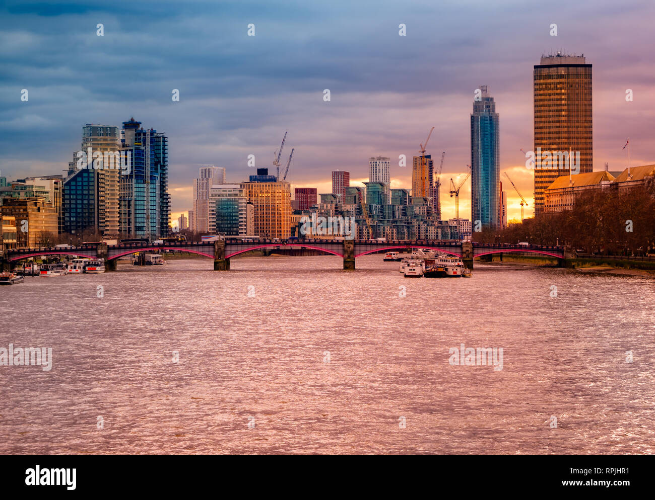 Hermosa vista panorámica de los famosos edificios de negocios y el río Támesis iluminado al atardecer, el paisaje urbano de Londres en el Reino Unido Foto de stock