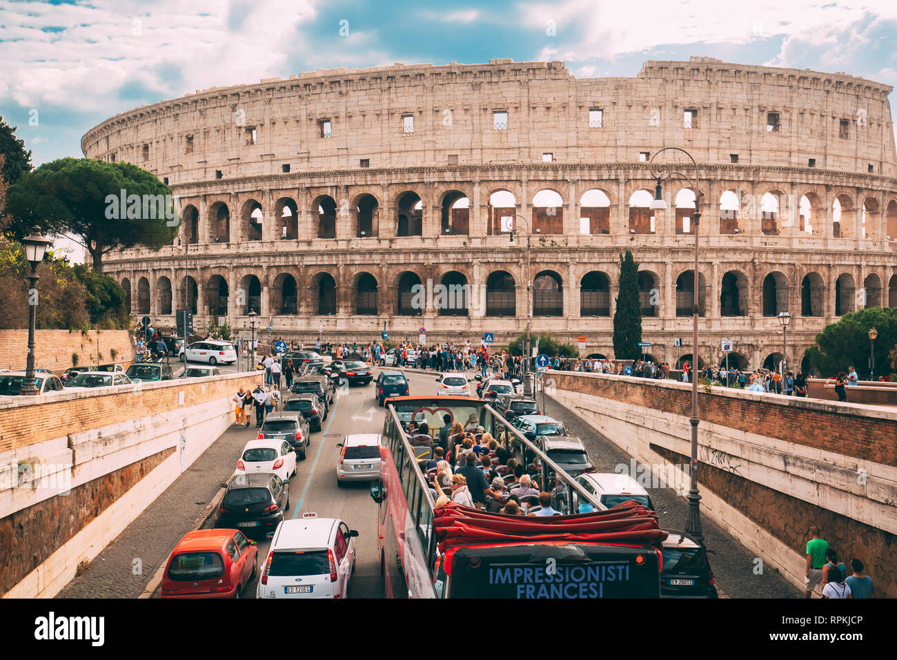 Roma, Italia - 21 de octubre de 2018: el Coliseo. Rojo Hop On Hop Off bus turístico para visitar en la calle cerca de anfiteatro Flavio. Famoso en el mundo la UNESCO L Foto de stock