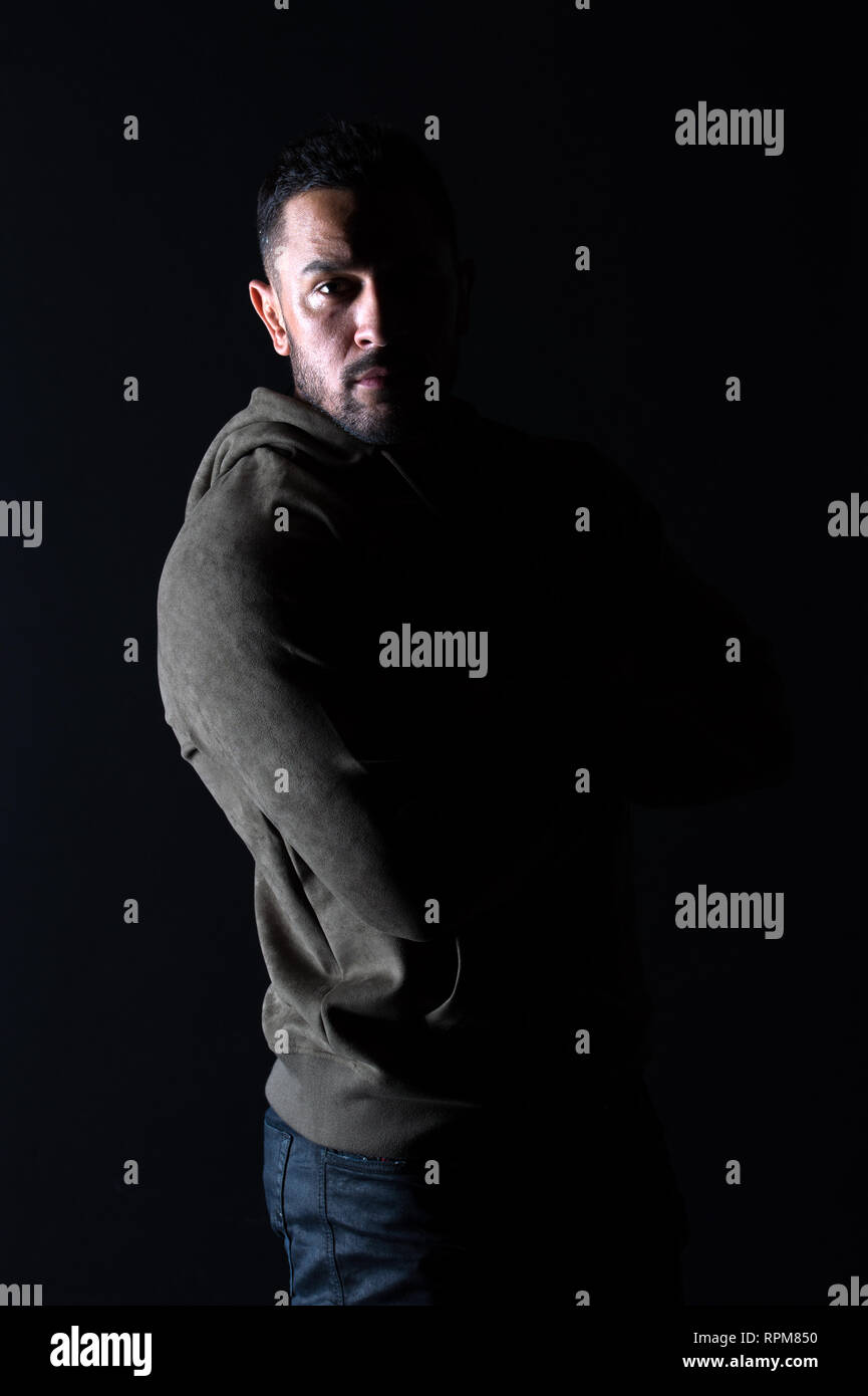 El deporte de moda y estilo. Macho con barba lleve ropa informal. Hombre  Barbado en sudadera sobre fondo oscuro. Modelo de moda en ropa deportiva y  elegante. Estilo de vida activo y