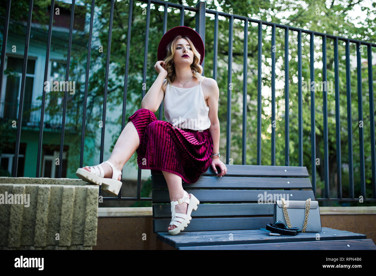 Moda y hermosa chica rubia modelo en terciopelo rojo falda de terciopelo, blusa blanca, sombrero y planteados en el Fotografía de stock - Alamy