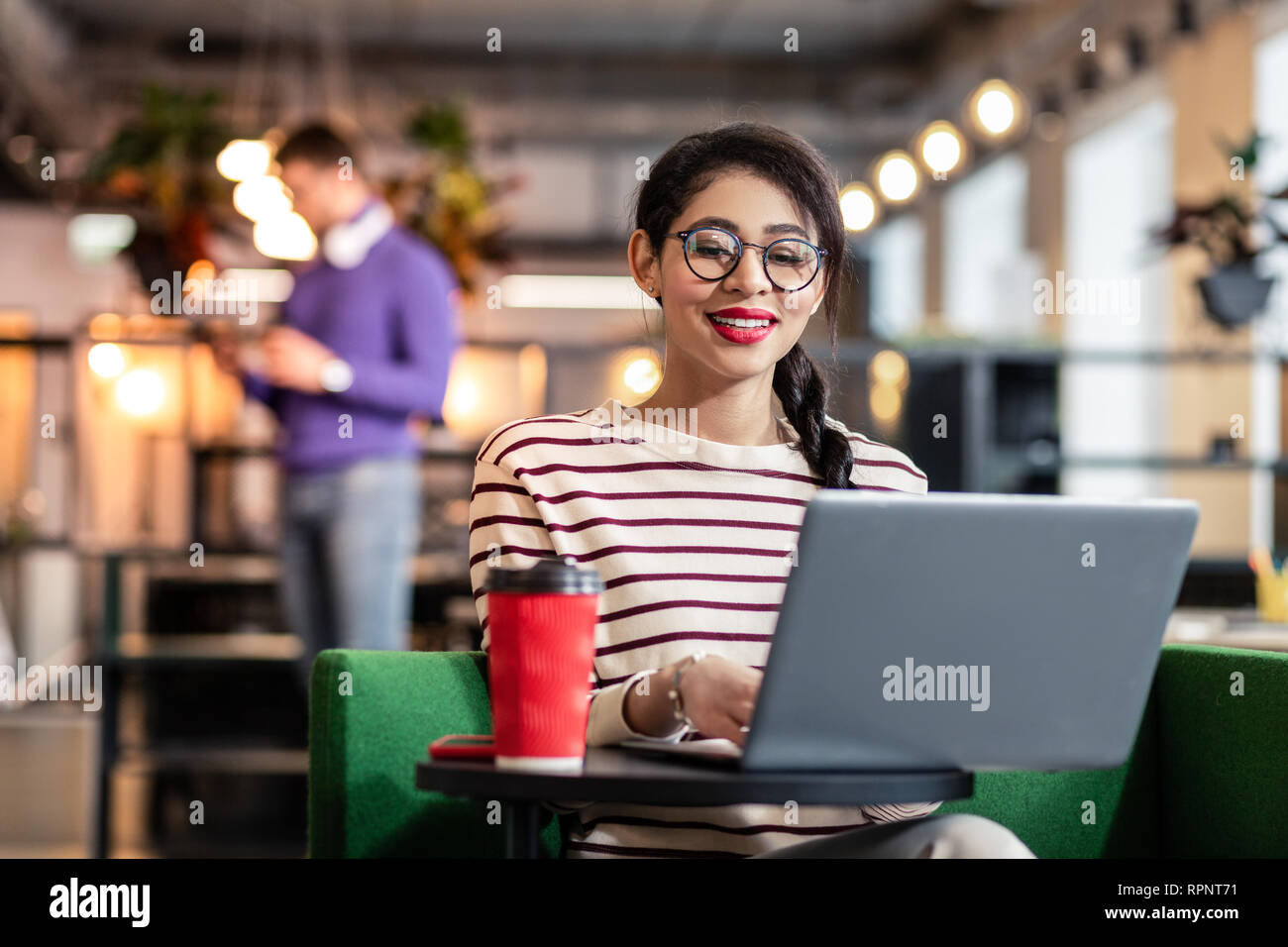 Niña morena encantadora trabajando en su portátil Foto de stock
