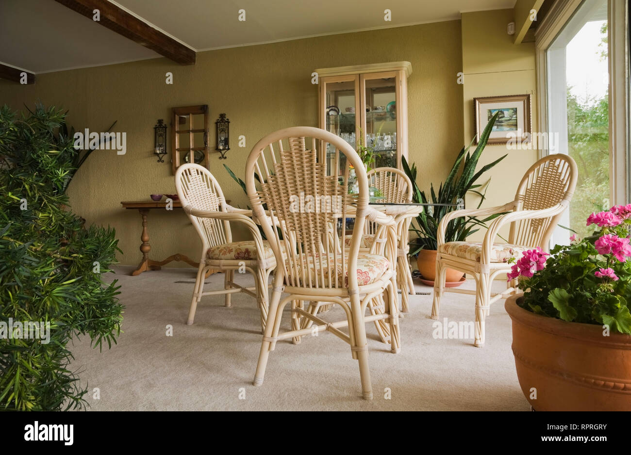 Mesa, sillas de mimbre y muebles en el comedor de una antigua Canadiana y  francés manoir estilo casita home Fotografía de stock - Alamy